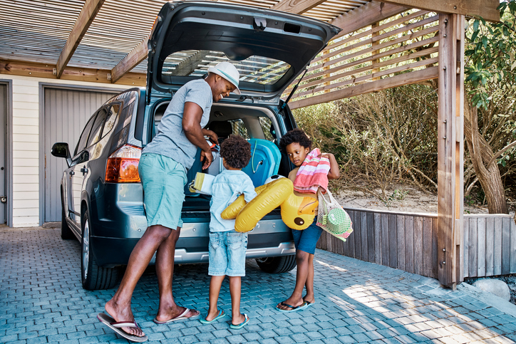father and children packing car for beach trip