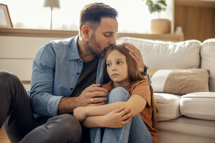 father comforting sad daughter