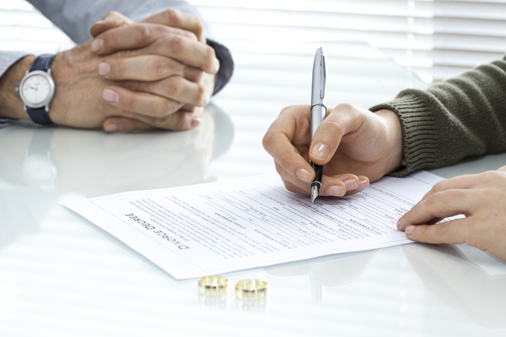 couple signing divorce papers in lawyer's office