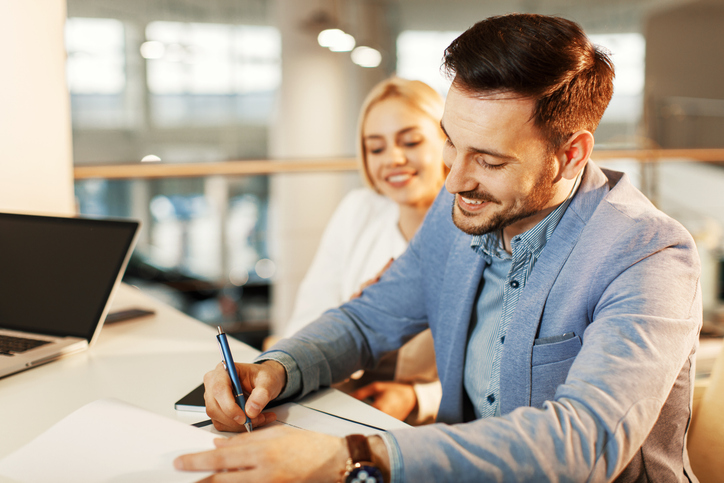 happy couple signing documents in an office