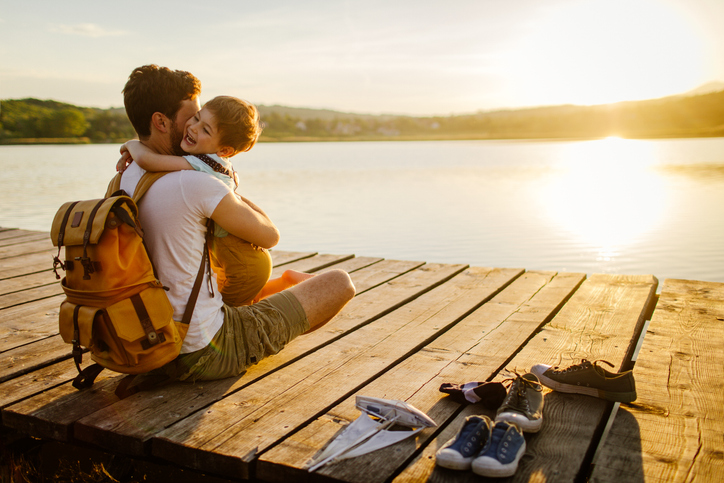 father and son hugging on a dock